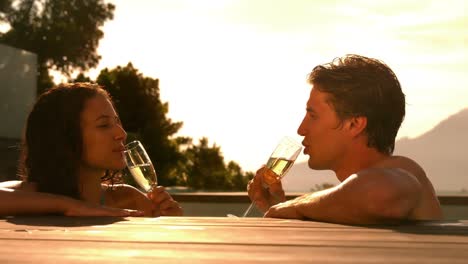 Pareja-Feliz-Bebiendo-Champán-Juntos-En-La-Piscina