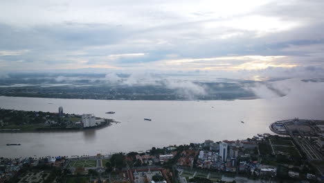 Aerial-timelapse-that-pans-over-the-Mekong-River-that-is-flowing-through-Phenom-Penh,-Cambodia-in-the-morning