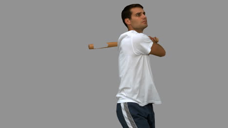 hombre guapo jugando al béisbol en la pantalla gris