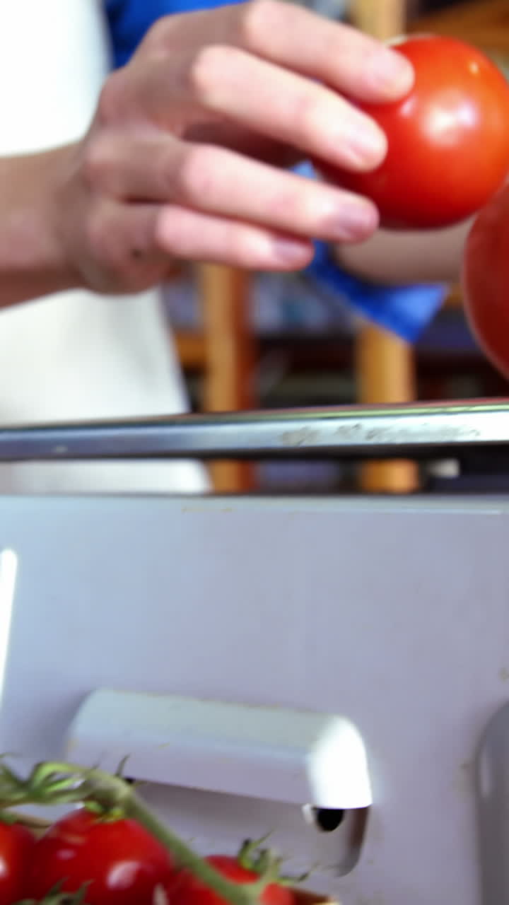 여성 직원 들 이 슈퍼마켓 에서 토마토 를 무게 로 측정 하고 있다