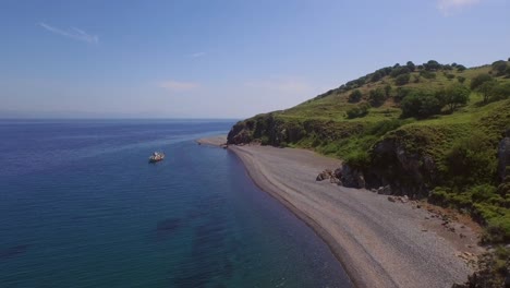 antena: una playa tranquila con un barco de pesca en lesbos, cerca de turquía