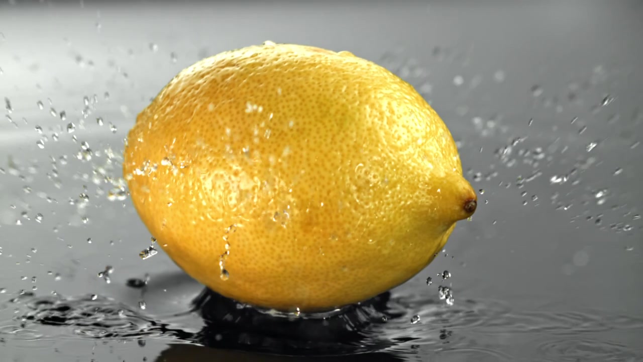 Limone fresco che cade e schizza nell'acqua al rallentatore
