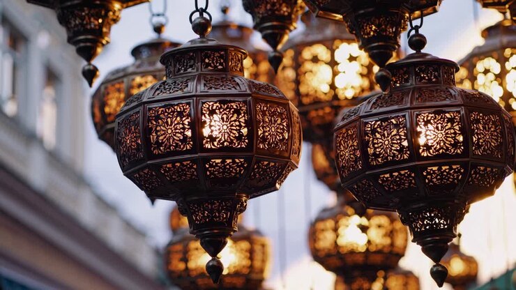 Lanterne di metallo decorate con motivi intricati, illuminate da una luce calda