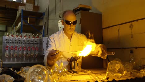 front view of mature male worker creating glass in glass factory 4k