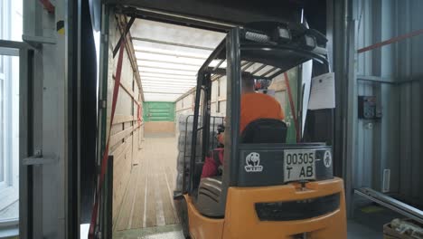 forklift driver transports packaged water bottles in warehouse