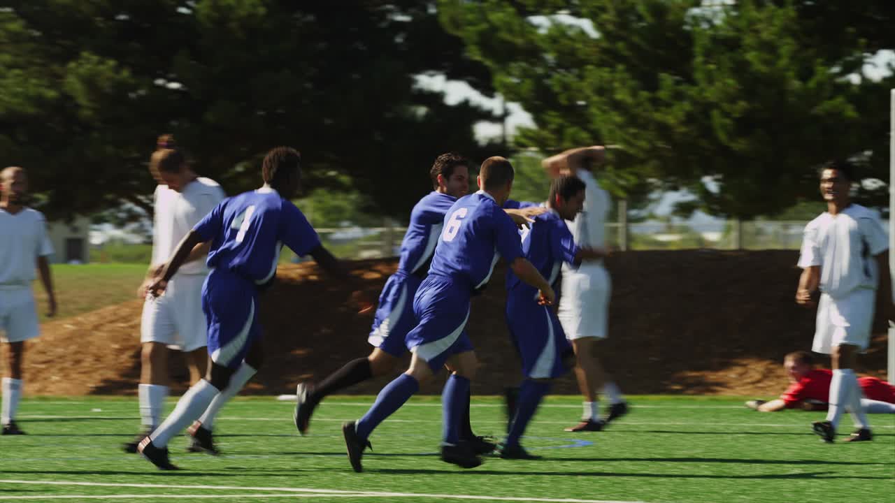 A soccer team passes the ball down the field and makes a goal
