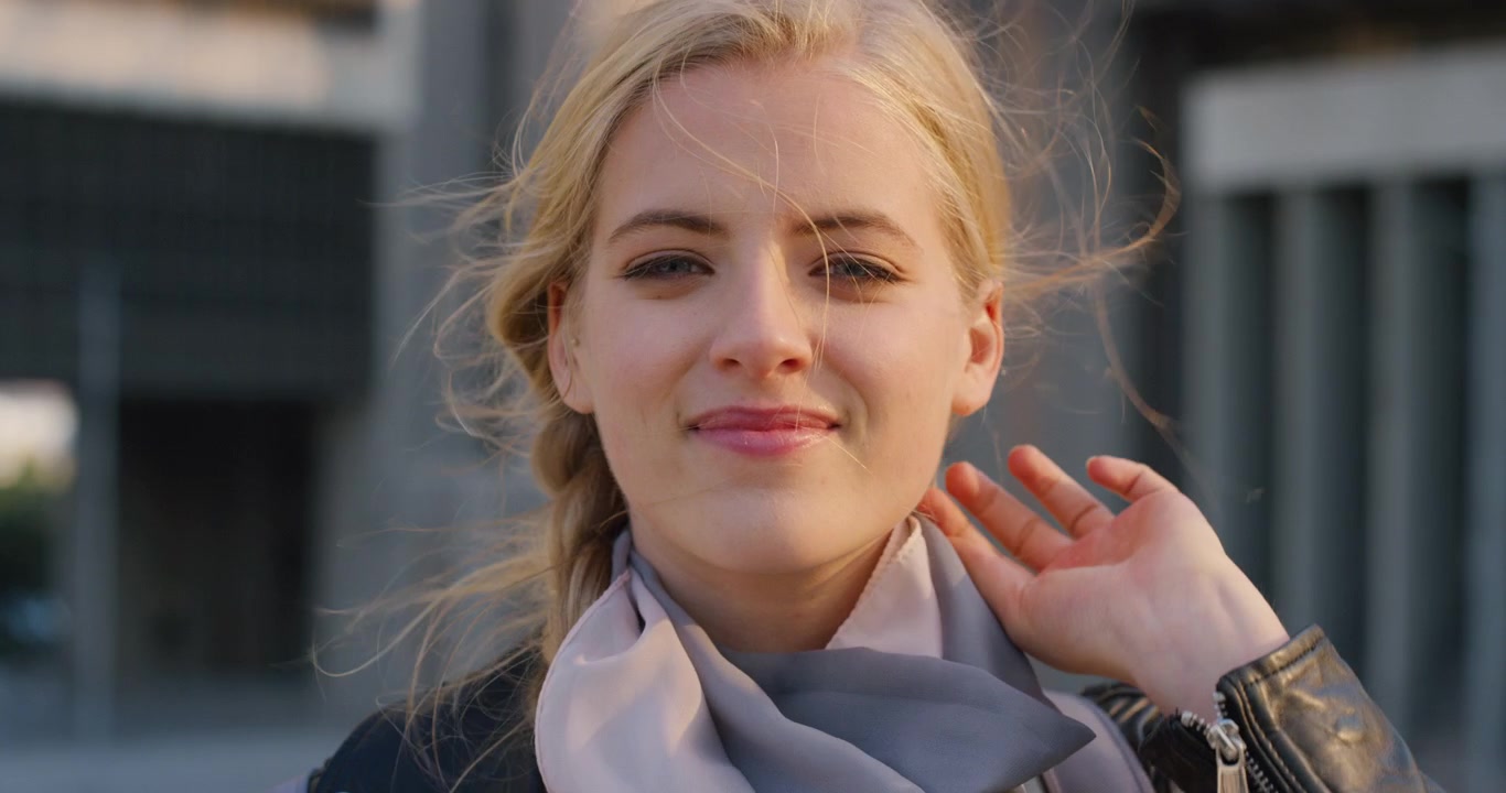 Young Blonde Woman Adjusting Her Hair Outdoors