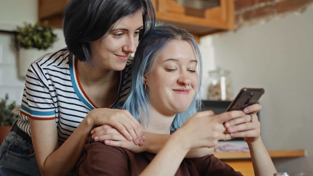 video de mano de mujeres navegando algo en el teléfono.