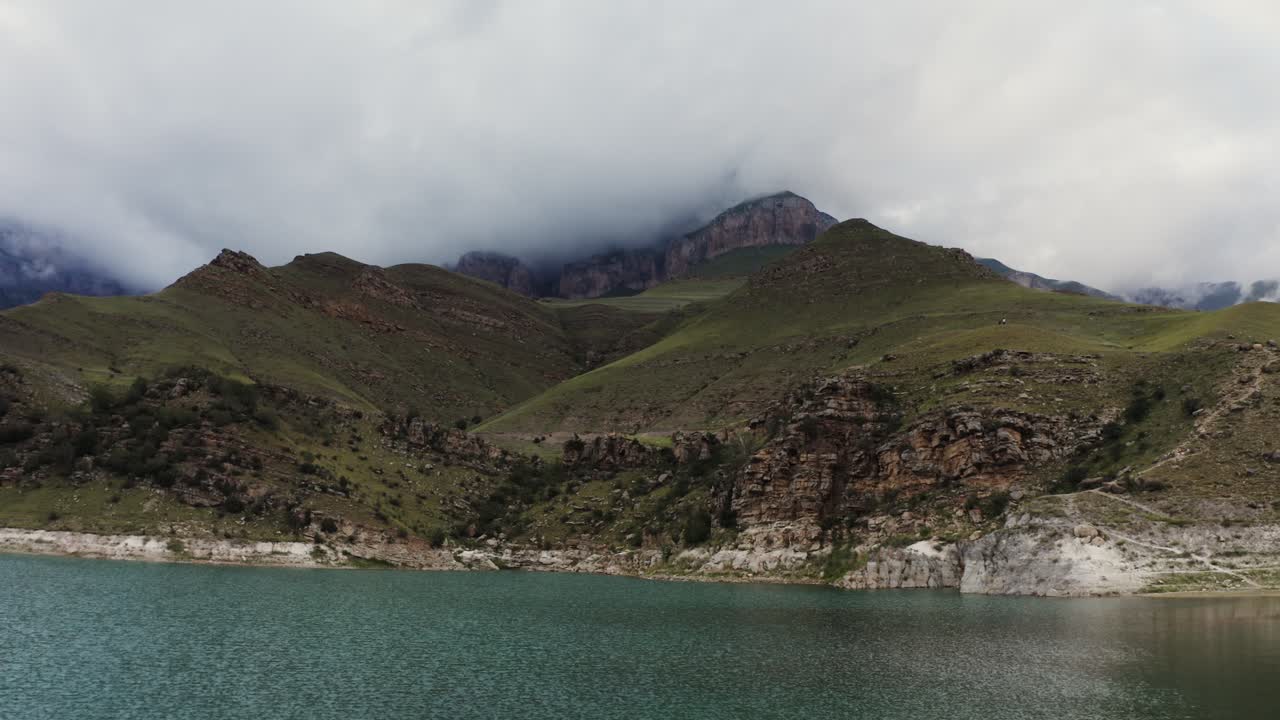 paisaje montañoso con lago y cielo nublado