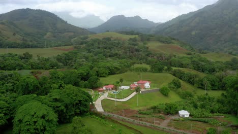 Tiro-Asombroso-En-Las-Montañas-De-Bonao,-Casa-En-El-Fondo,-Nubes,-Vegetación-Verde