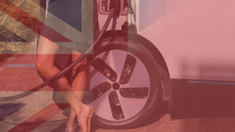 flag of great britain over low section of woman charging electric car