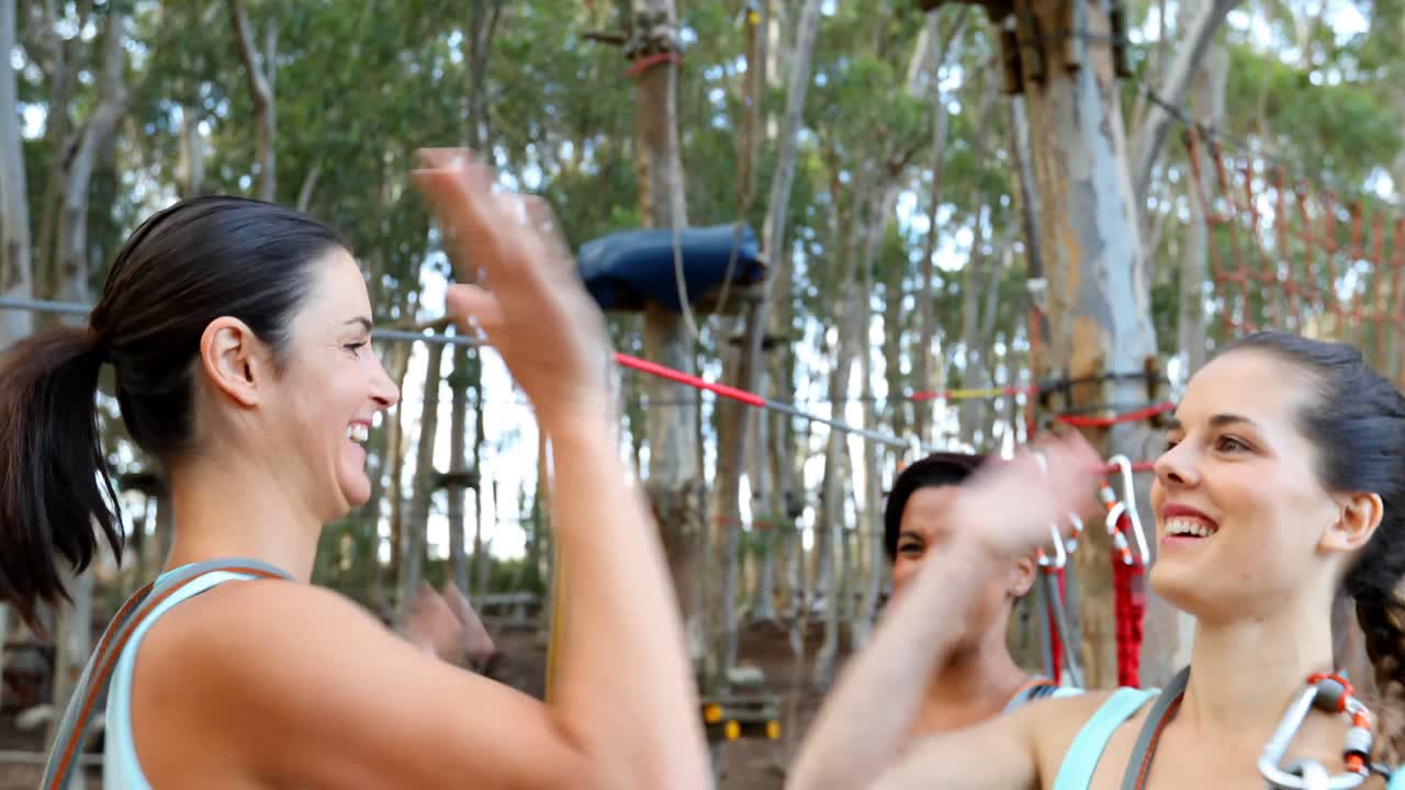 amigos felices ayudando a arreglar el arnés y dando un alto cinco 4k 4k