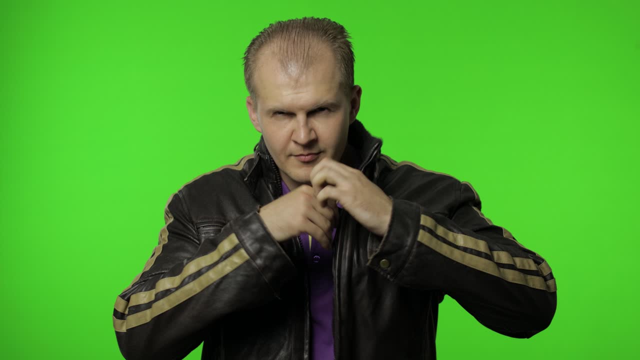 잔인한 로커 남자가 재에서 심장 몸짓을 꺼내서 만적 인 감정을 보여주고 있습니다.