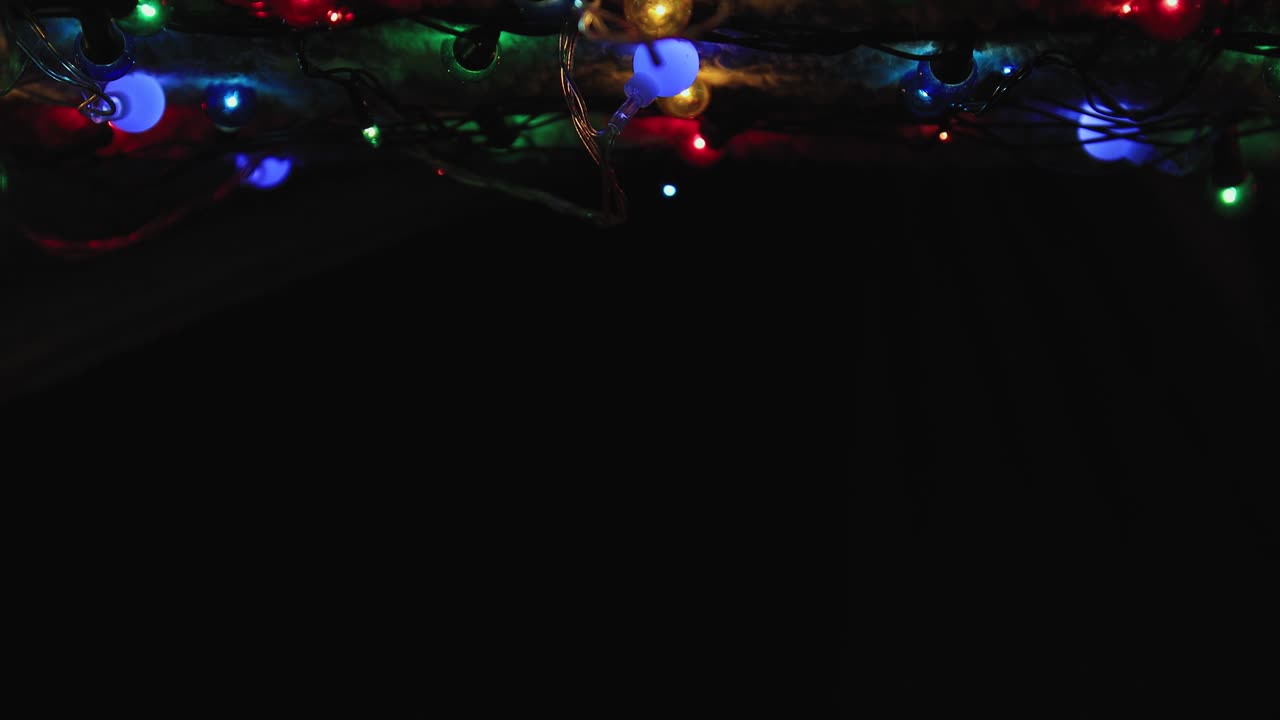 вверху - сказочные цветные рождественские огни на черном фоне.