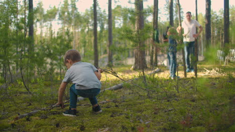 two little boy collecting firewood in the forest. two little brothers in the forest gather wood together and build a fire