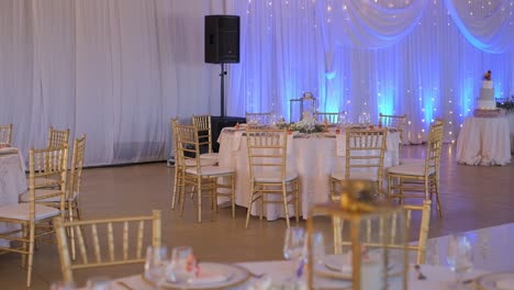 stylish gold plated chairs and tables at wedding reception - wide shot