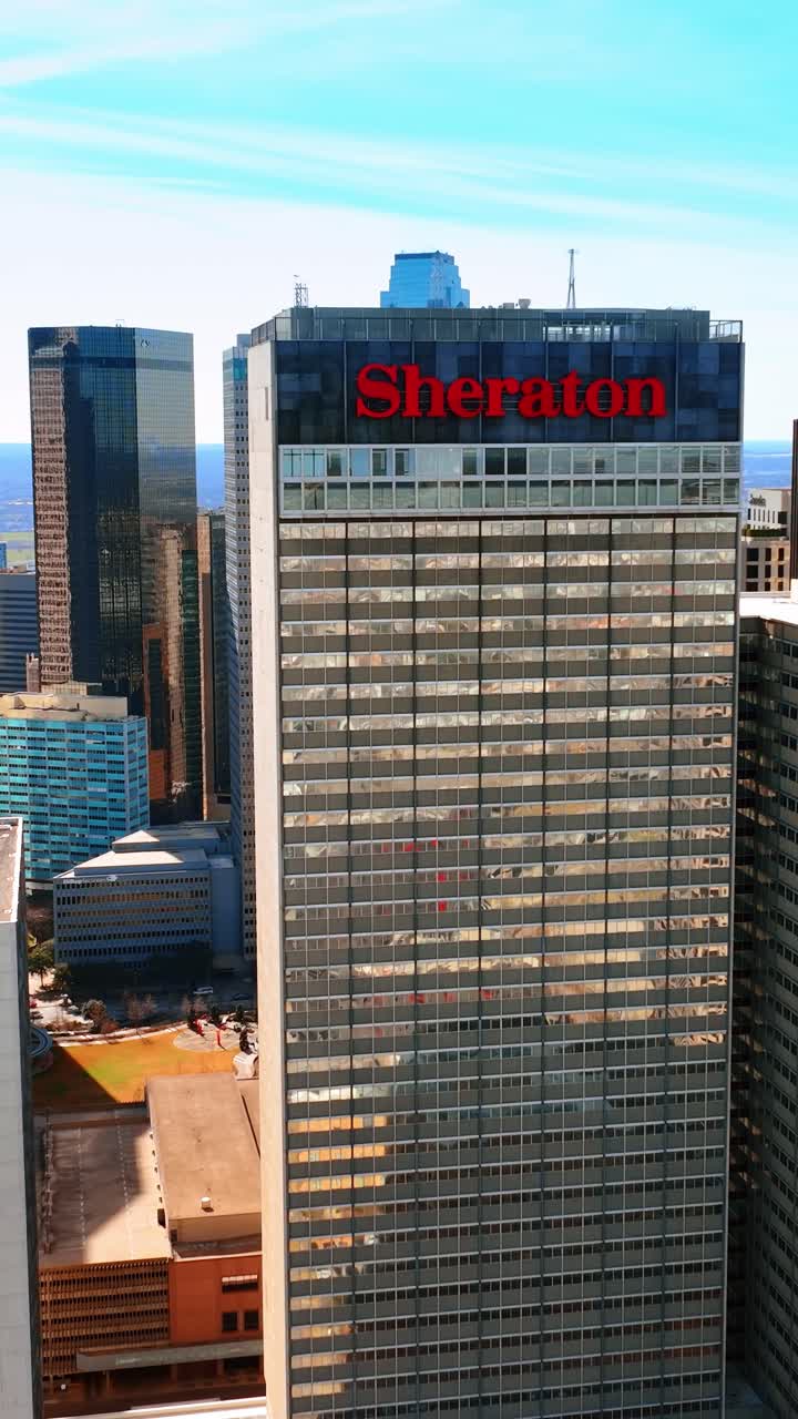 Sheraton Dallas Hotel, edificio con una grande immagine di un bambino e altri splendidi grattacieli nel centro della città. Drone che vola intorno all'architettura a Dallas, Texas, USA.