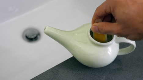 salt being mixed with distilled water in a neti pot