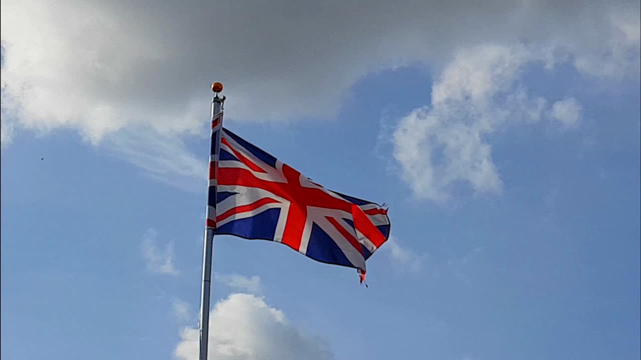 푸른 하늘을 배경으로 바람에 날리는 영국 연합 깃발