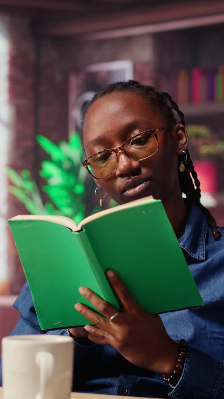 Afroamerikanische Frau liest ein Buch mit Brille