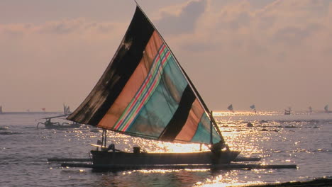 a man guides a sailboat to shore