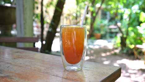 Té-De-Limón-Helado-En-Vaso-Sobre-Mesa-De-Madera