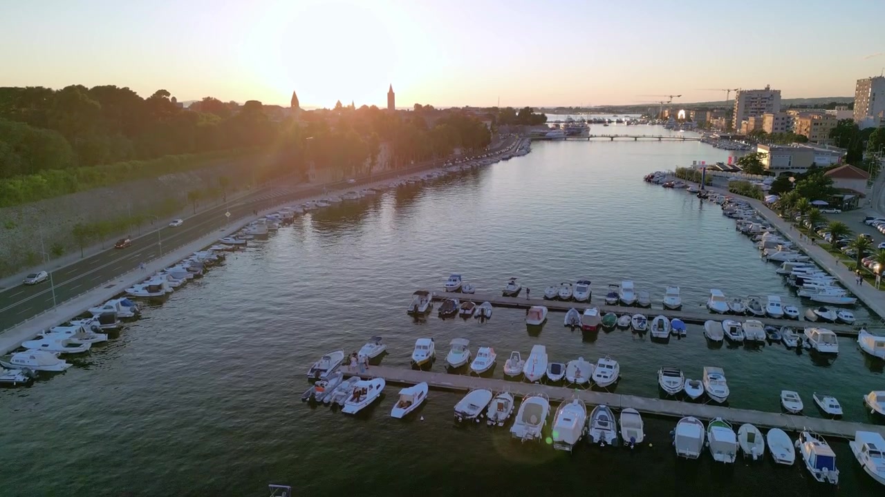 Pouso de um drone sobre a cidade de Zadar, na Croácia, ao pôr do sol. Vista dos barcos atracados na marina Jazine
