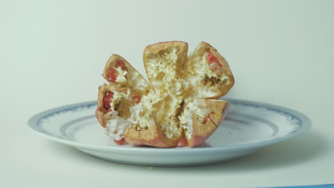 Empty-pomegranate-being-placed-on-plate