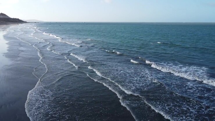 Riprese con drone all'indietro di un mare calmo con poche onde su una spiaggia deserta nel Brasile nord-orientale