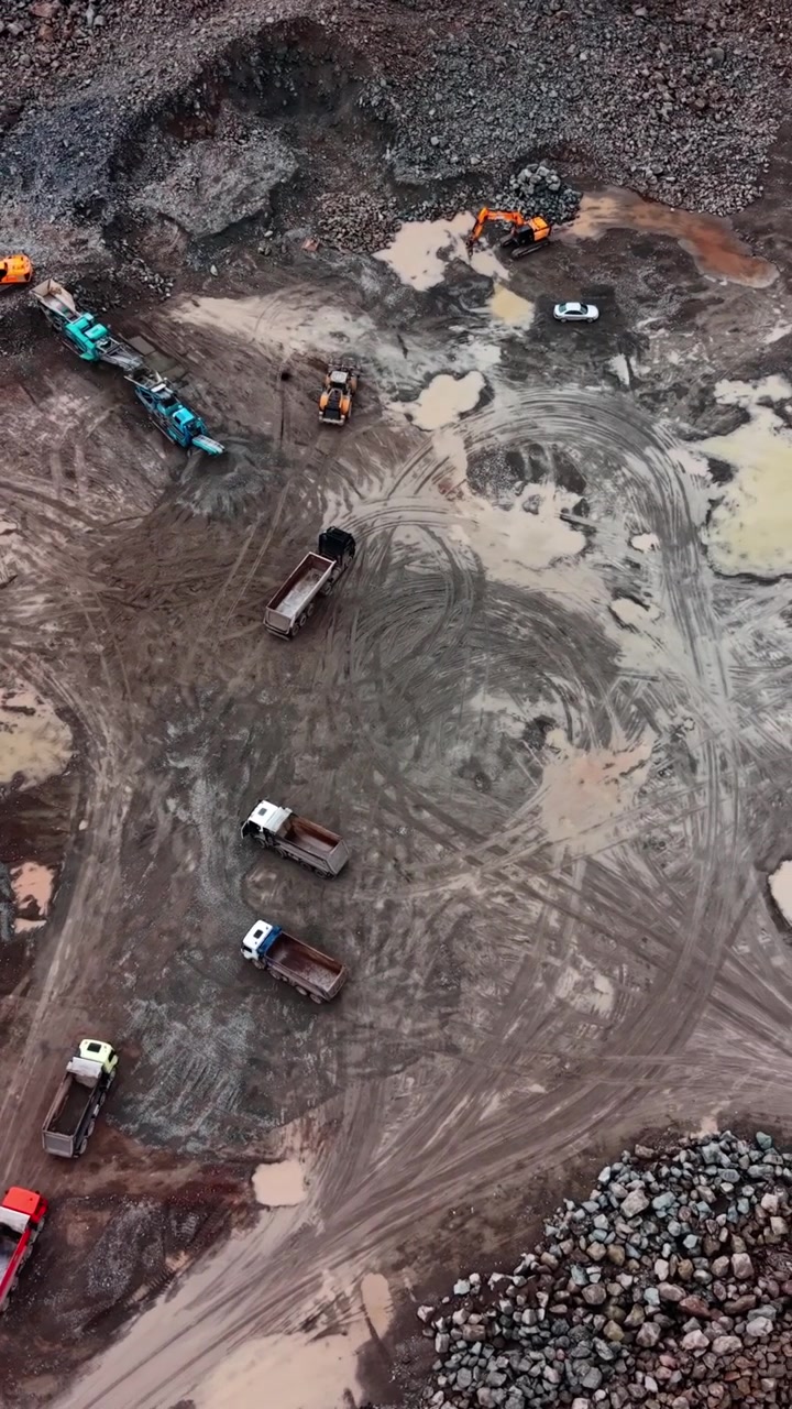 Aerial View of Heavy Machinery and Trucks at a Muddy Construction Site