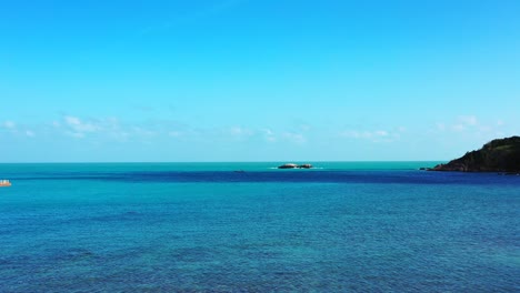tranquil bay with blue turquoise shallow lagoon washing cliffs and rocky coastline of tropical island under bright sky at sunrise in myanmar