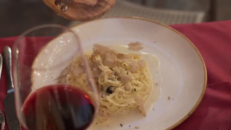 fresh truffles are shaved onto a plate of pasta in siena, italy.