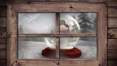 animation of snow falling over snow globe with snowman in winter scenery seen through window