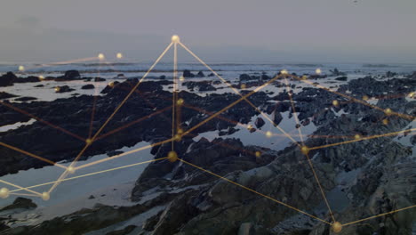 flat design network overlay floating above rocky shoreline, with golden nodes and luminous lines