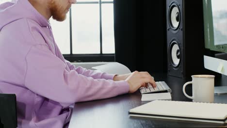 man working on computer in music studio