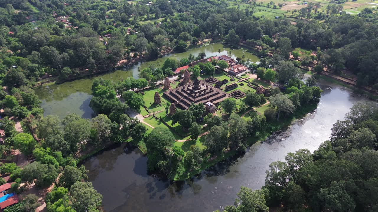 Aerial establishing orbit of Bakong Temple ruins surrounded by lush jungle near Siem Reap, Cambodia