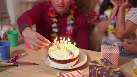 friends celebrating a birthday with cake and candles
