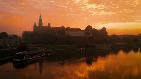 Drone-footage-of-Wawel-Royal-Castle-at-magic,-cloudy-dawn-with-soft,-morning-sunlight,-Krakow-,-Poland