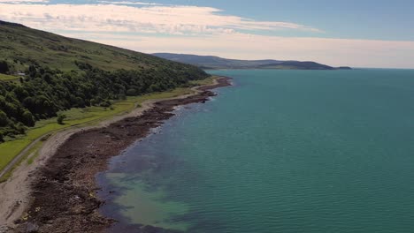 aerial footage showing beautiful scottish coastline on the isle of arran on a sunny day