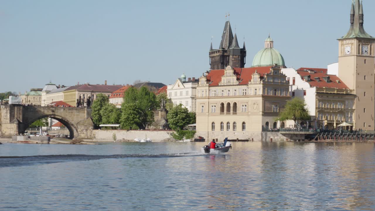 Veduta cinematografica dell'iconico Ponte Carlo sul fiume Moldava, che rivela una vista della Torre dell'Acqua della Città Vecchia, Praga, Repubblica Ceca