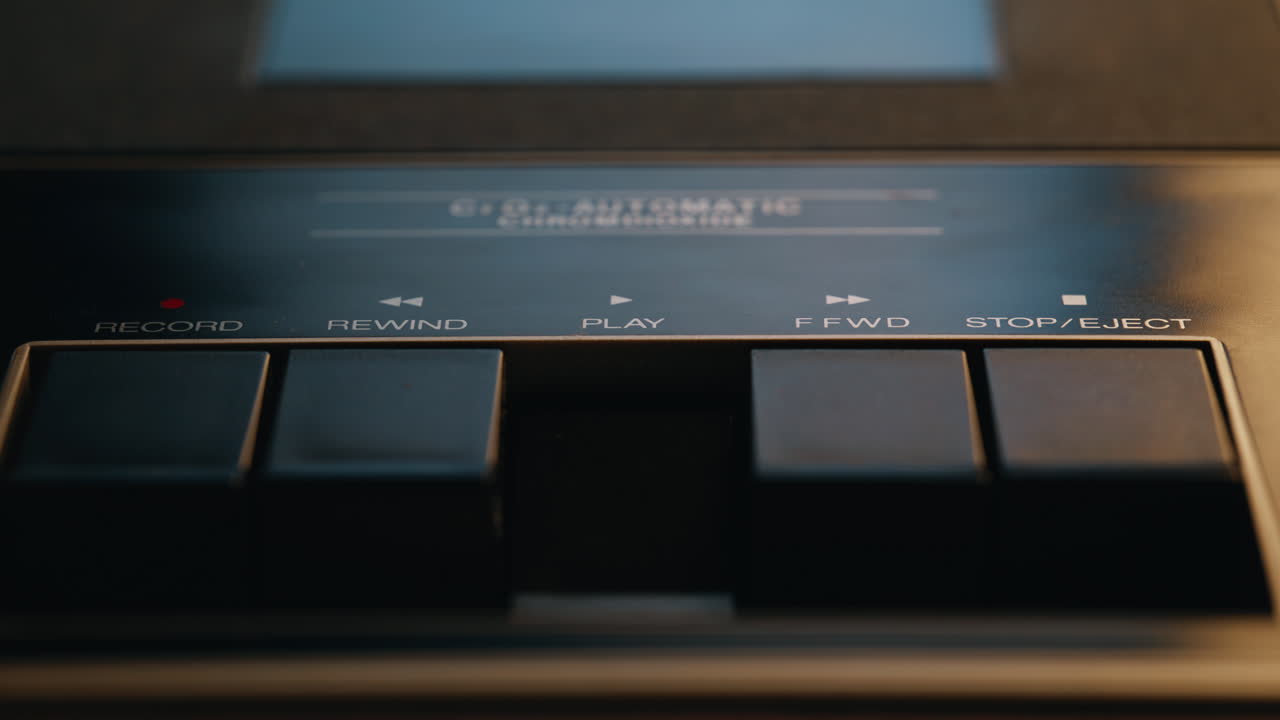 Closeup hand pressing play on old audio deck. Music enthusiast touching player