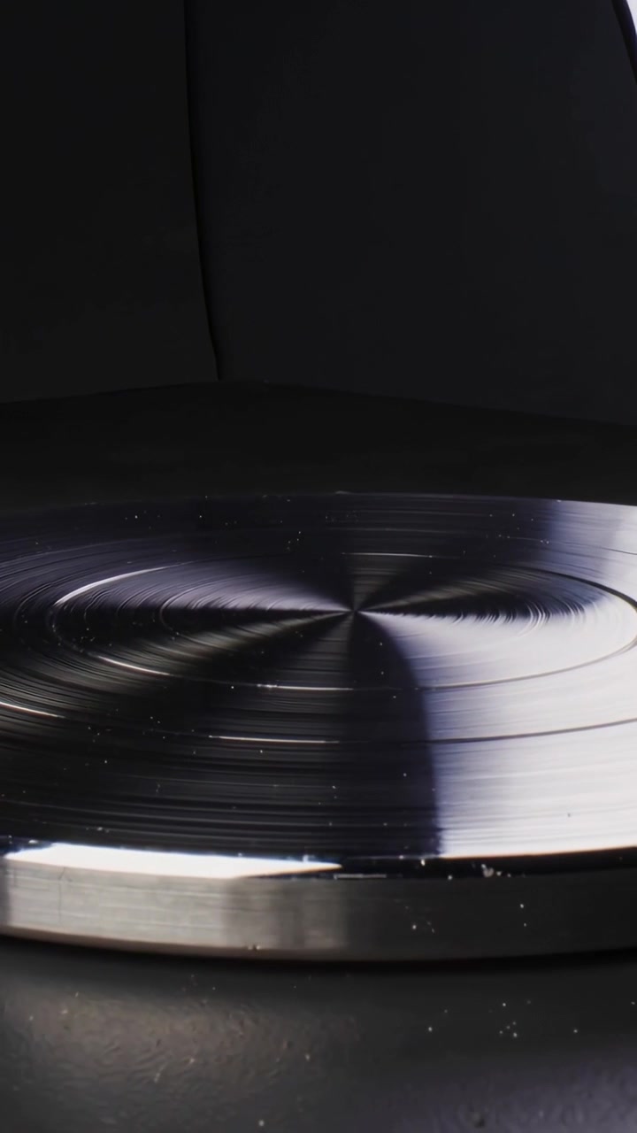 Video verticale: Disco metallico rotante che mostra scanalature e polvere sulla scrivania all'avvio della telecamera, test softbox.
