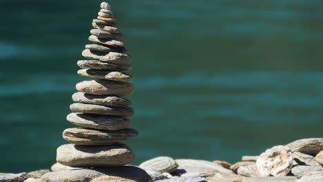 smooth, round, flat stones stacked into a cairn along a riverbank