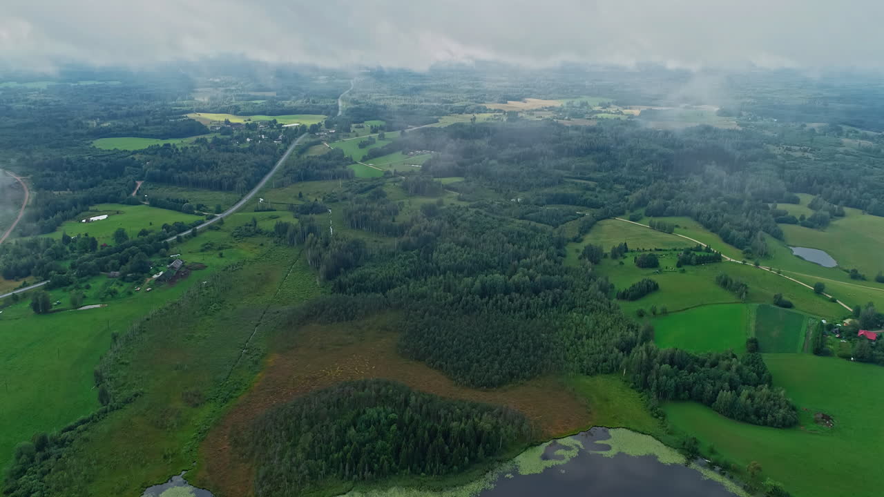 aérea por encima de las nubes y un hermoso paisaje verde con pastizales y árboles