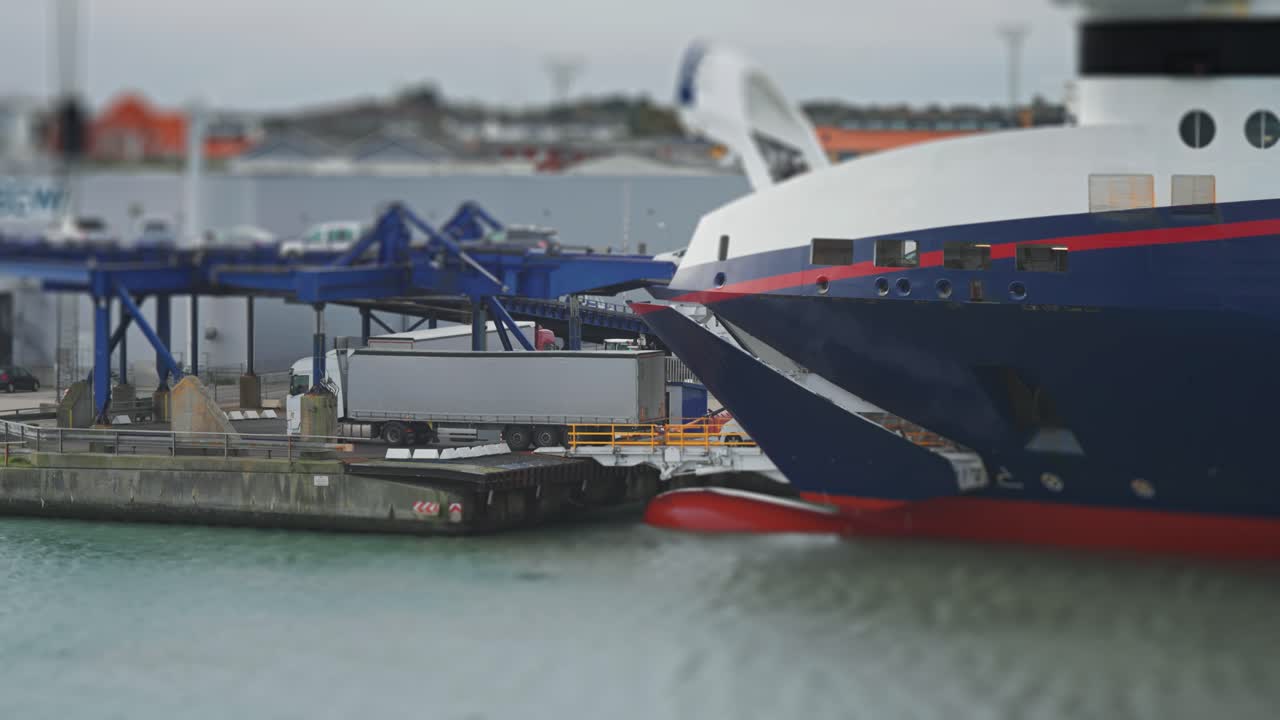 자동차와 트럭이 히츠할스 항구의 페리에서 내려갑니다.