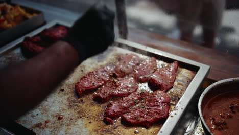 Chef-on-festival-seasoning-steaming-steaks-sizzling-on-grill