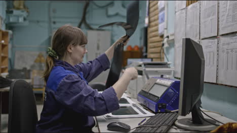 woman inspecting documents in a factory setting