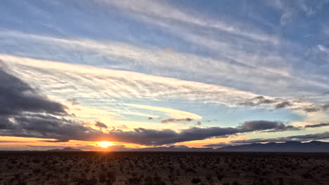 dawn breaks over mojave desert with dynamic cloud play, timelapse