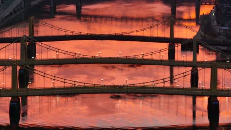 Roberto-Clemente,-Andy-Warhol,-and-Rachel-Carson-bridges-during-orange-sunset-reflection-on-Allegheny-river