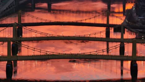 roberto clemente, andy warhol, and rachel carson bridges during orange sunset reflection on allegheny river